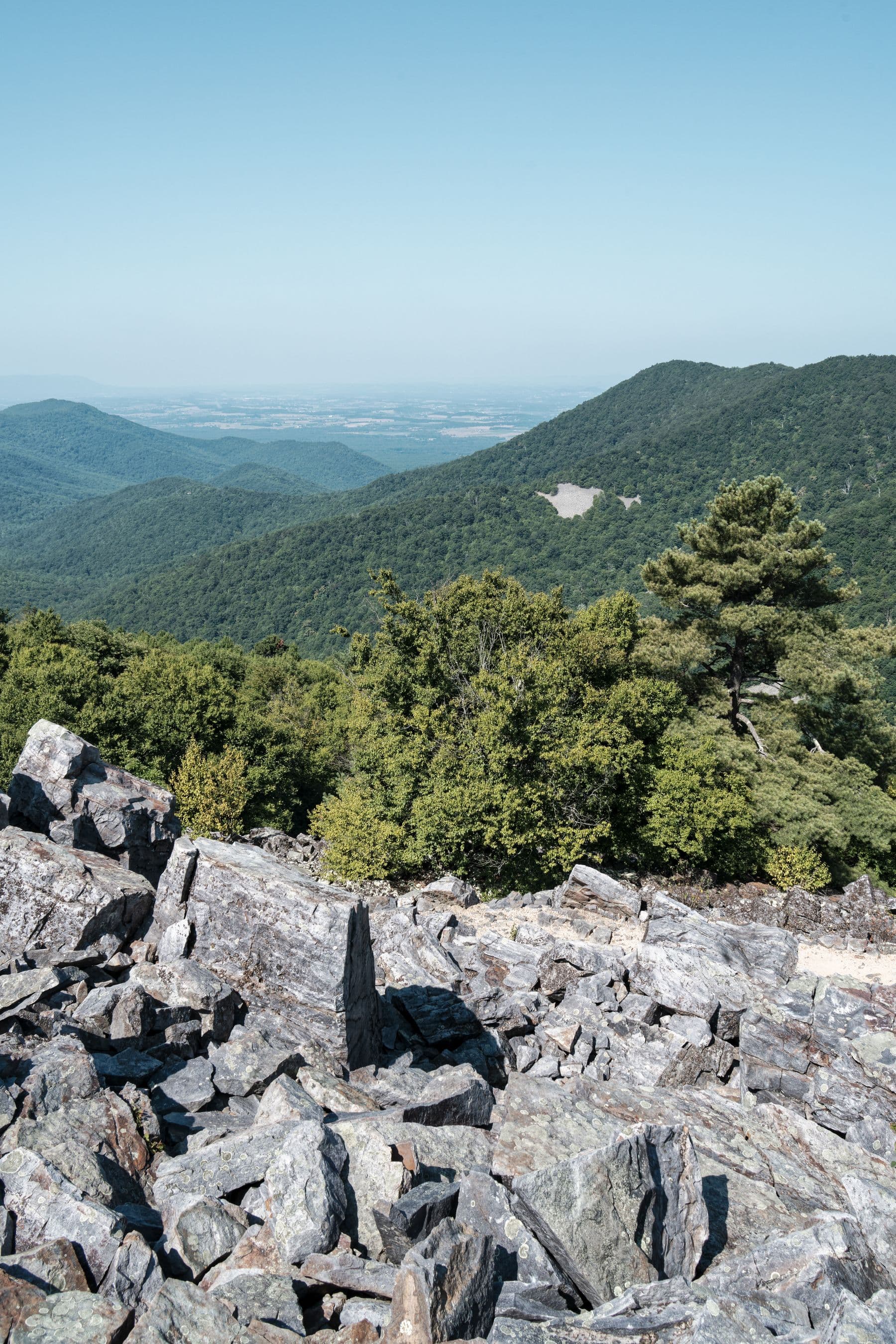 A rocky overlook with wooded Blue Ridge ridgelines stretching into the distance