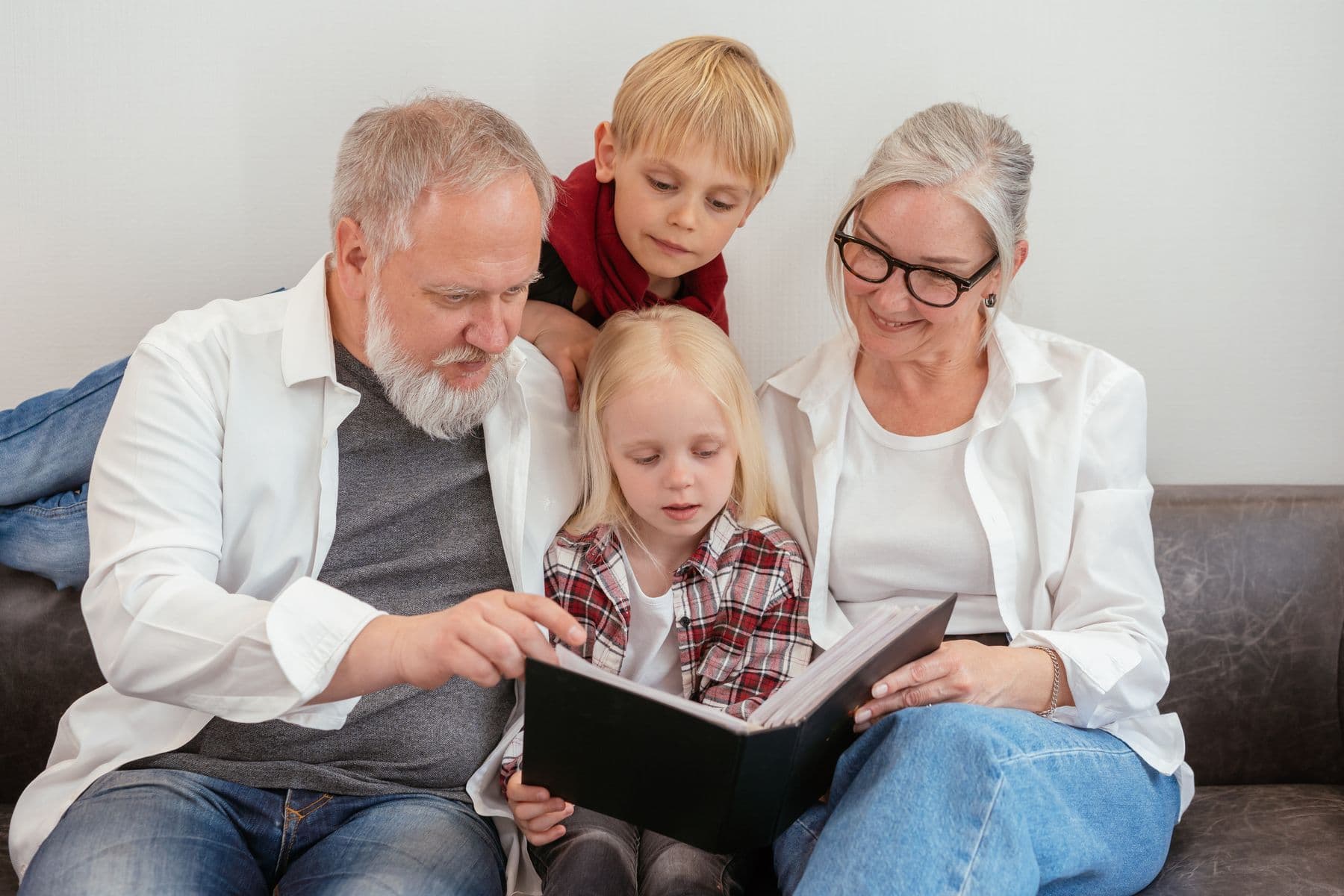 Grandparents and grandchildren looking through a photo album
