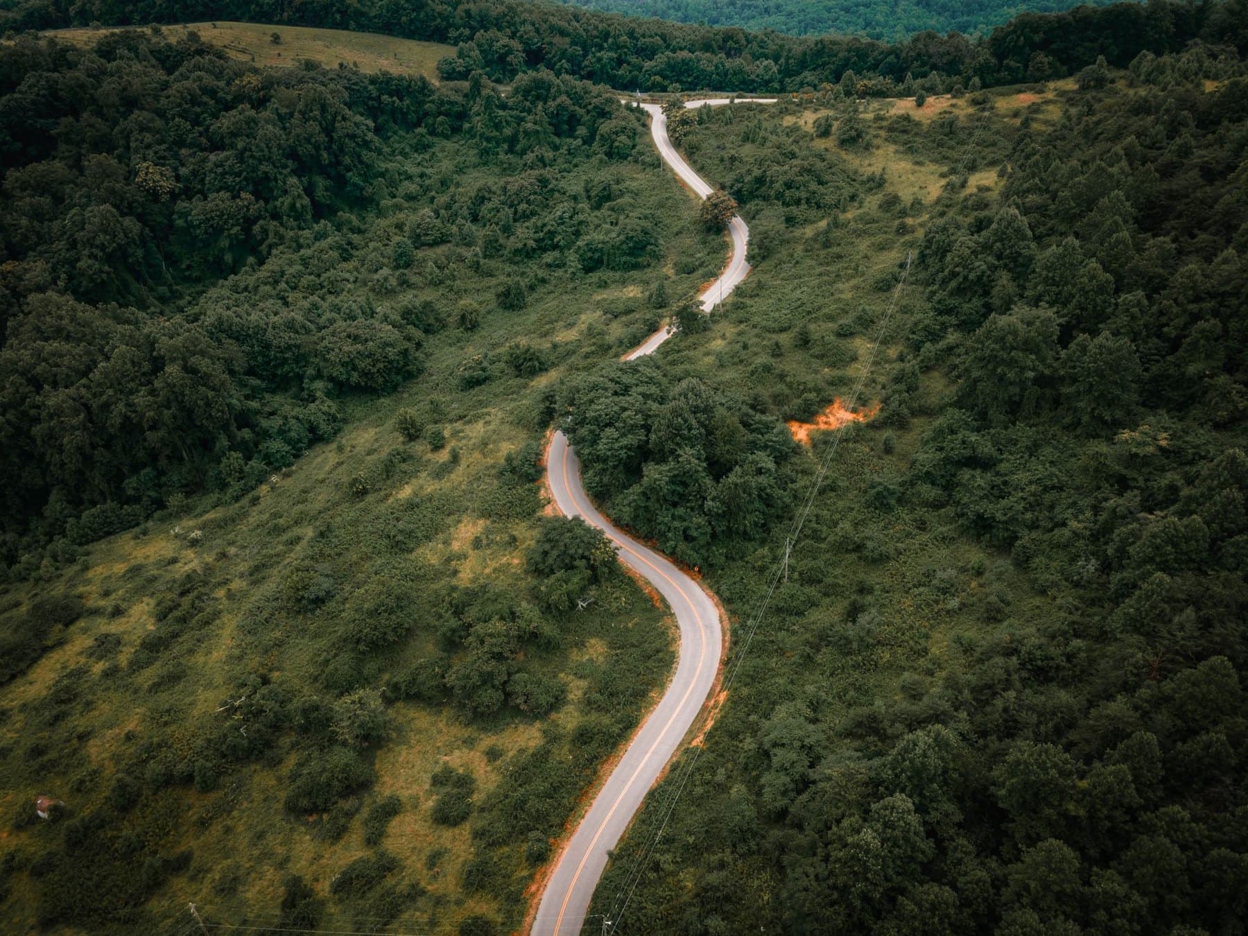 An aerial view of a road winding through the wooded hills around Roanoke, Virginia