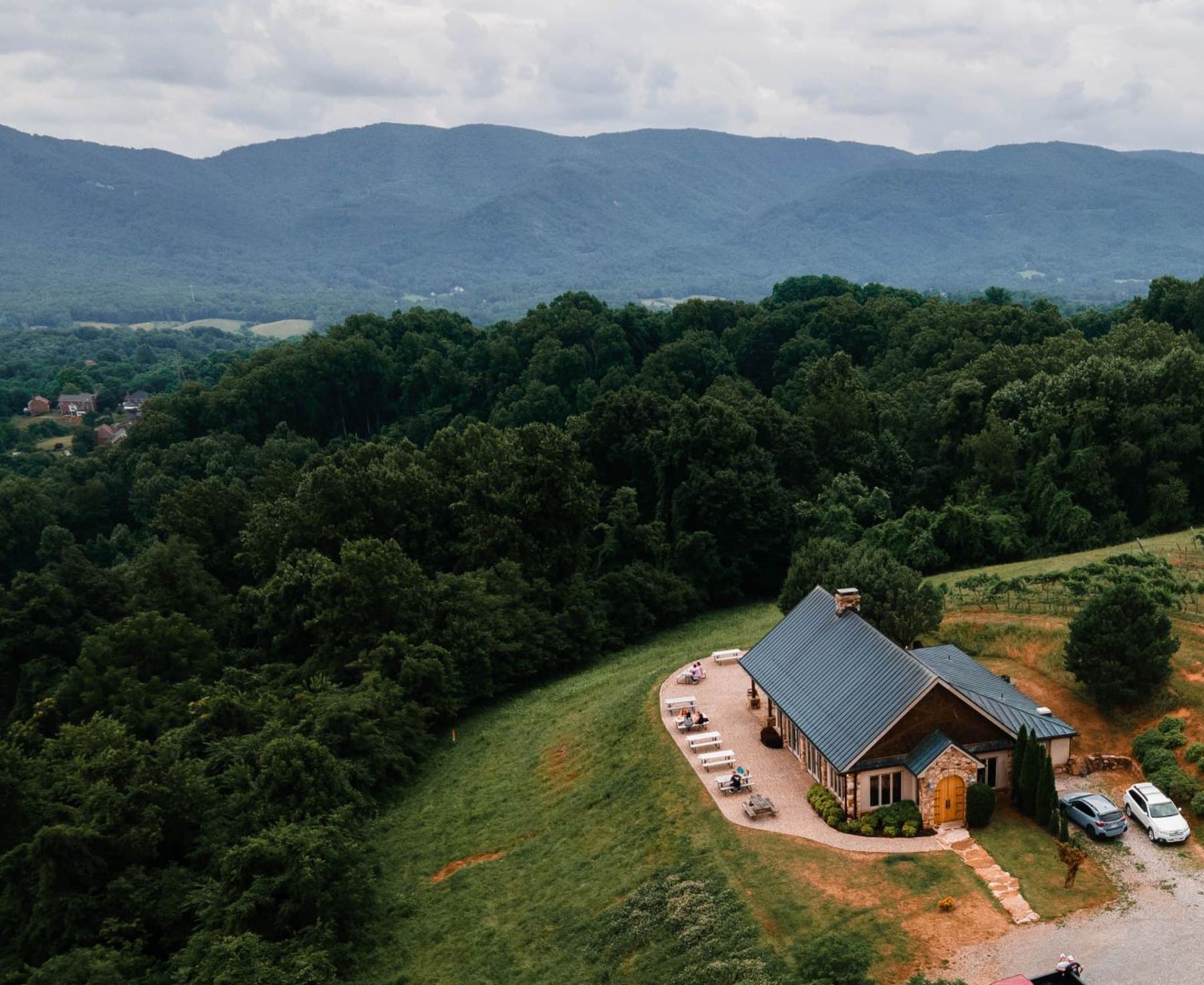 A house on a cleared hillside with wooded ridges and the Blue Ridge Mountains behind it, near Roanoke, Virginia
